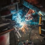 Intense close-up of a welder working on a project, showcasing sparks and safety equipment.