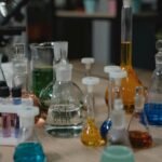 Various colored chemical liquids in glassware on laboratory table, perfect for scientific visuals.